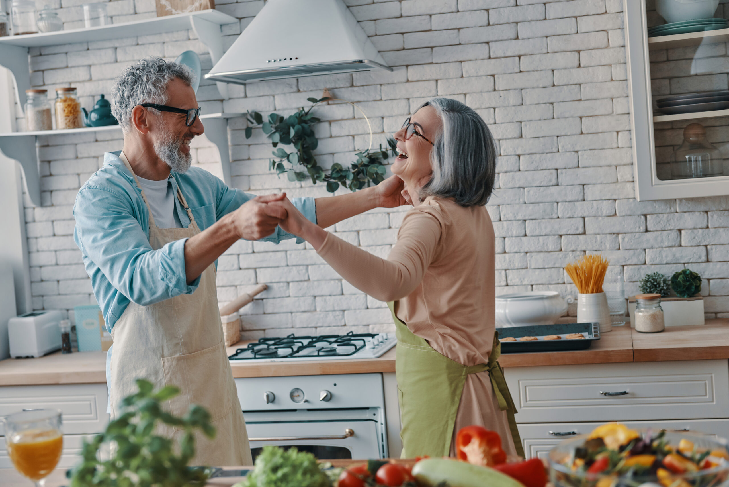 Retired couple dancing in kitchen